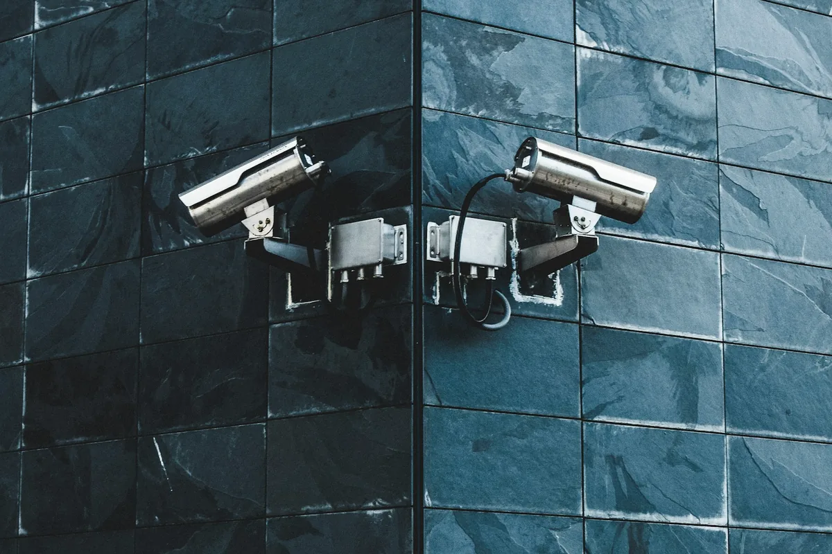 Close-up of a white IP security camera mounted under an eave