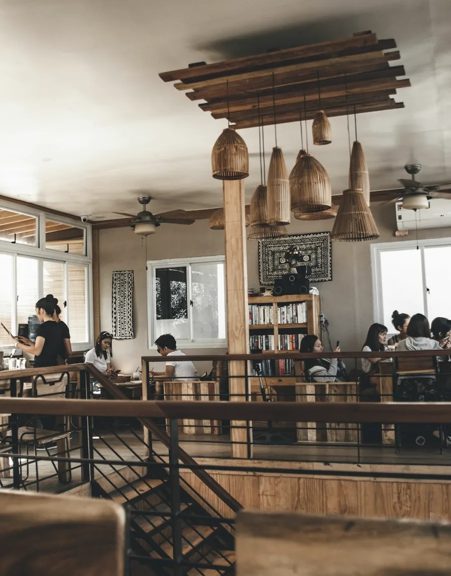 Interior of a hospitality venue with timber tables and pendant lighting