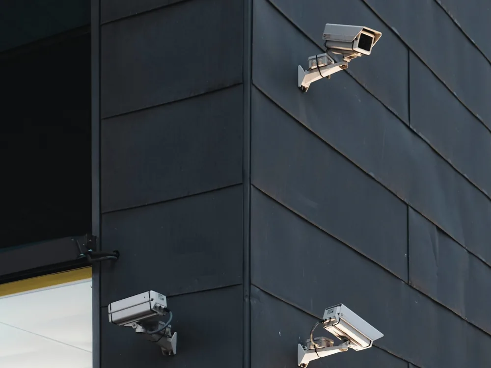 Two security cameras mounted on an exterior wall of a building