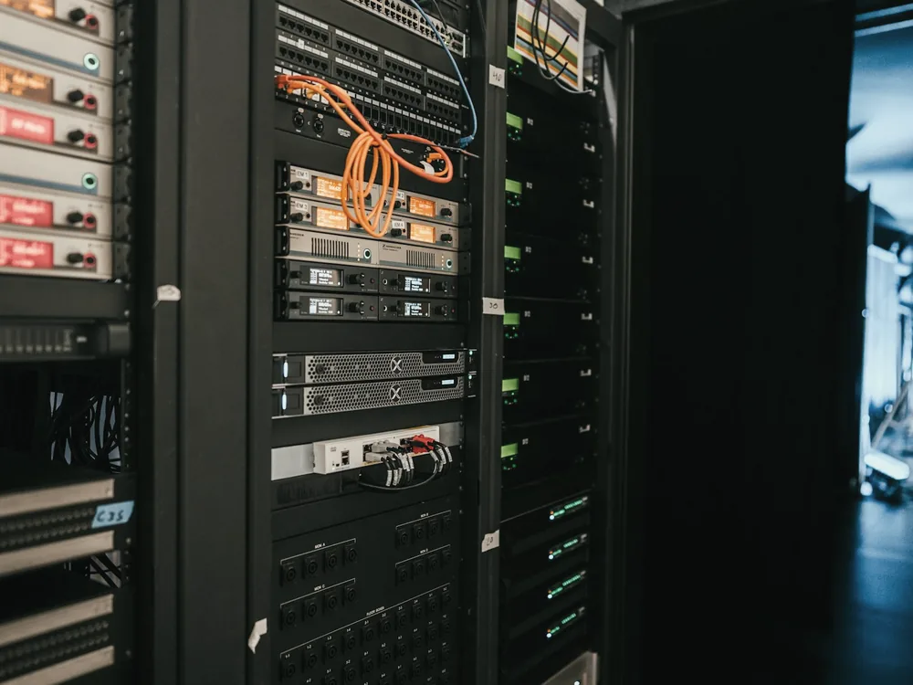 Rows of data centre racks with status lights along a cold aisle