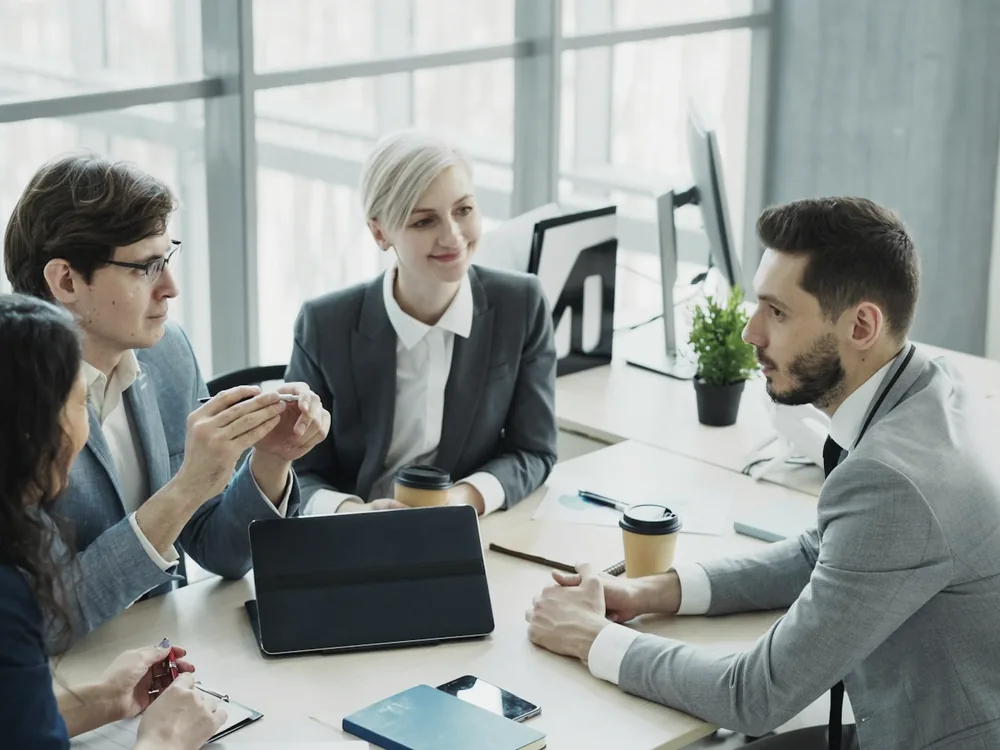 People working at desks in a bright open-plan office